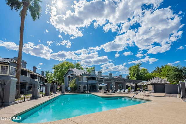 community pool with a patio and fence