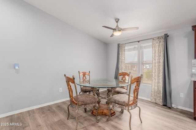 dining room featuring light wood-type flooring, baseboards, and ceiling fan