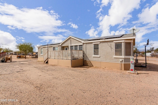 rear view of property with solar panels