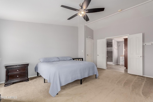 bedroom with light carpet, ensuite bathroom, baseboards, ceiling fan, and vaulted ceiling