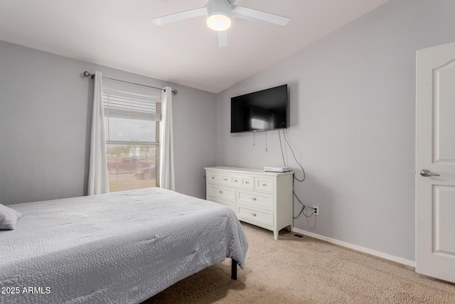 bedroom featuring baseboards, lofted ceiling, light colored carpet, and a ceiling fan