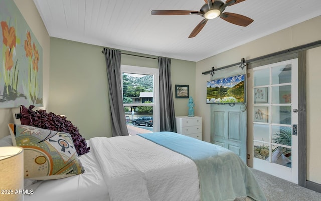 bedroom featuring a barn door, carpet, and a ceiling fan