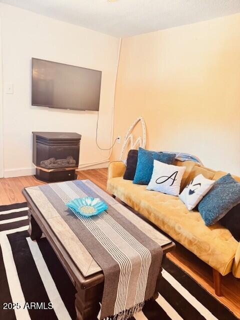 living area with baseboards and wood finished floors