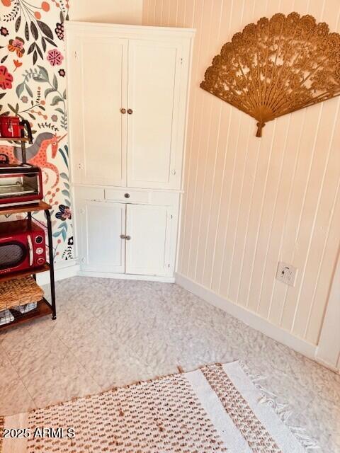 interior space featuring wooden walls and baseboards