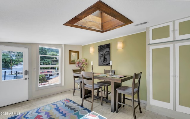dining space with visible vents, baseboards, and wood finished floors