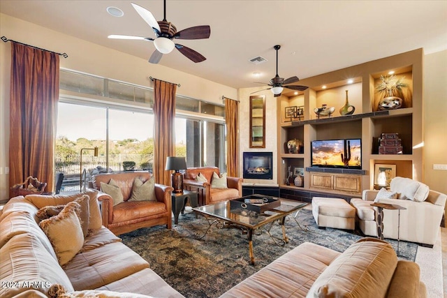 living room with ceiling fan and built in features