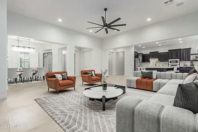 living room with ceiling fan with notable chandelier