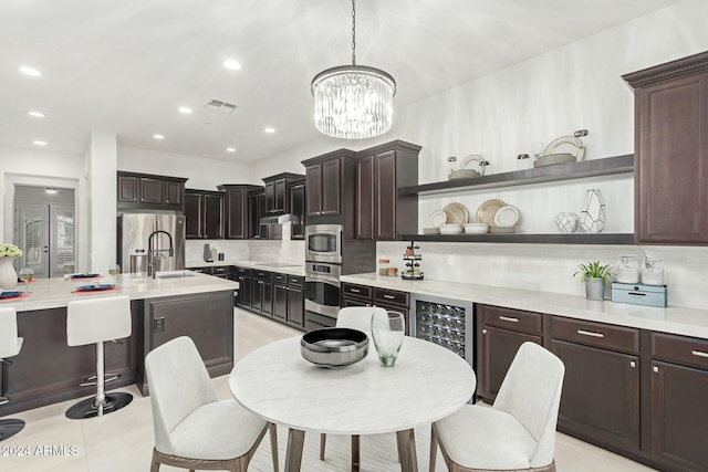 kitchen featuring tasteful backsplash, wine cooler, stainless steel fridge, hanging light fixtures, and dark brown cabinets