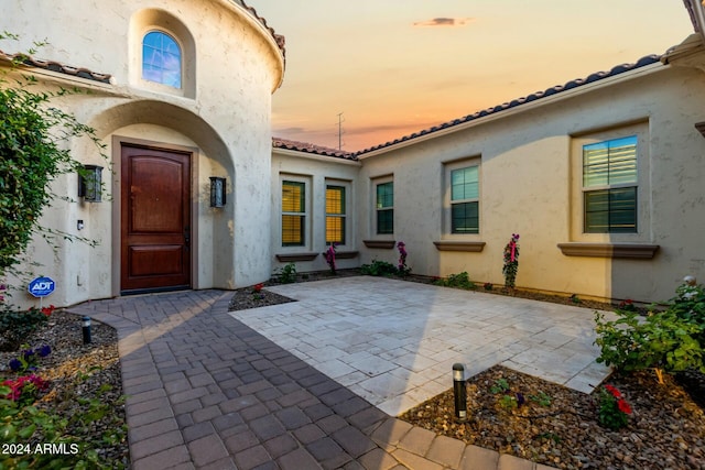 exterior entry at dusk with a patio