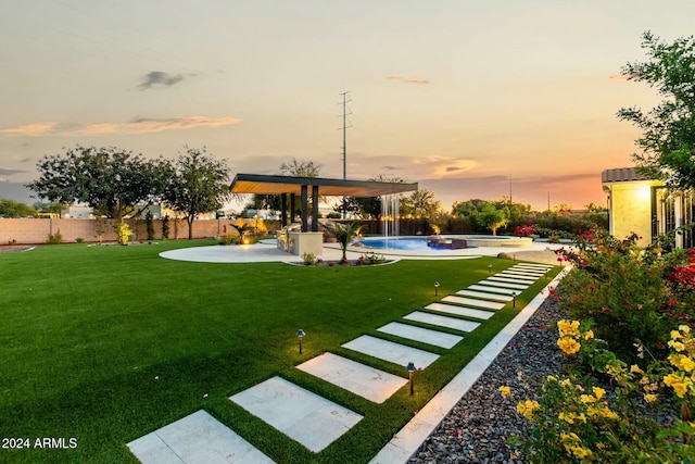 yard at dusk with a swimming pool with hot tub and a patio