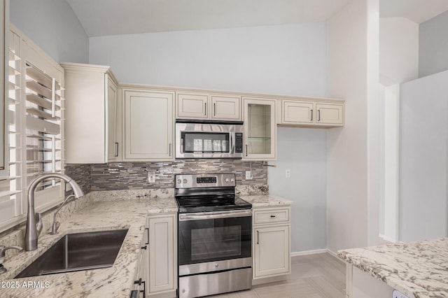 1712 E Saratoga St, Gilbert, AZ 85296 - kitchen featuring vaulted ceiling, a sink, decorative backsplash, cream cabinets, and stainless steel appliances