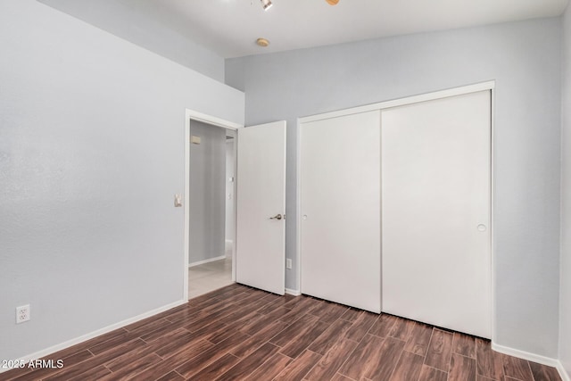 1712 E Saratoga St, Gilbert, AZ 85296 - unfurnished bedroom with baseboards, a closet, and dark wood finished floors