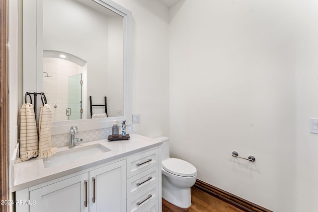 bathroom featuring hardwood / wood-style floors, vanity, toilet, and a shower with shower door