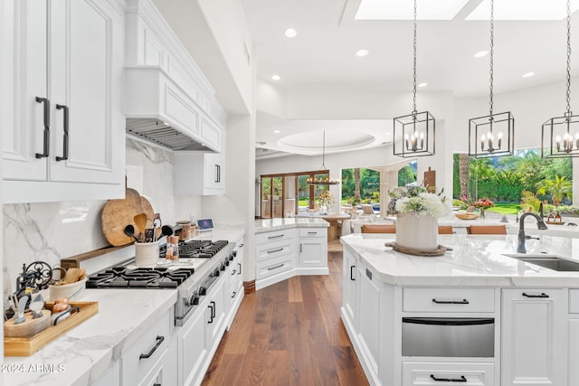 kitchen with decorative light fixtures, white cabinetry, sink, and dark wood-type flooring