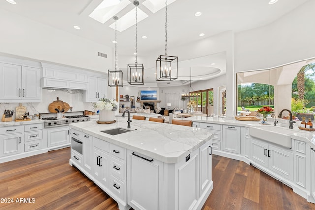 kitchen featuring white cabinetry, sink, an island with sink, and dark hardwood / wood-style floors