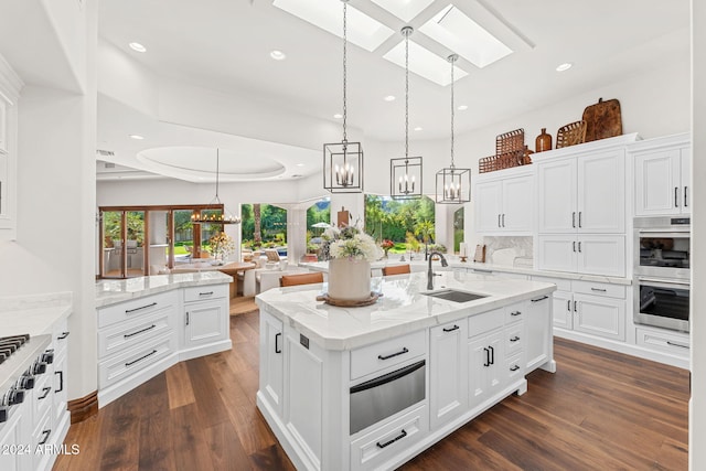 kitchen featuring sink, white cabinetry, and an island with sink