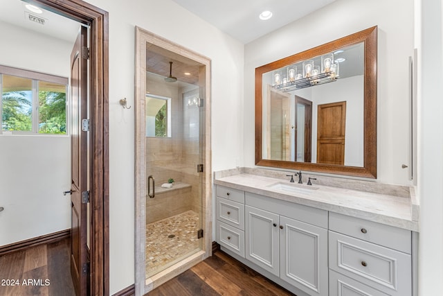 bathroom featuring hardwood / wood-style flooring, vanity, and a shower with door