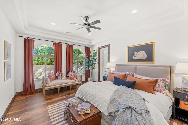 bedroom featuring a tray ceiling, ceiling fan, and dark wood-type flooring