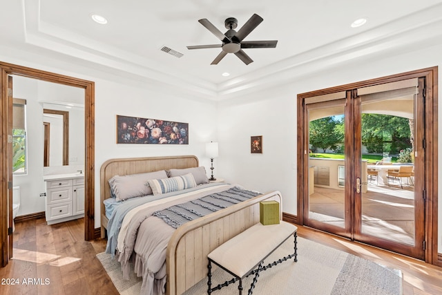 bedroom featuring ceiling fan, light hardwood / wood-style floors, ensuite bathroom, and access to outside