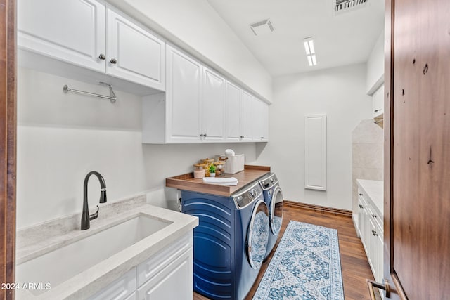 clothes washing area with cabinets, sink, wood-type flooring, and independent washer and dryer