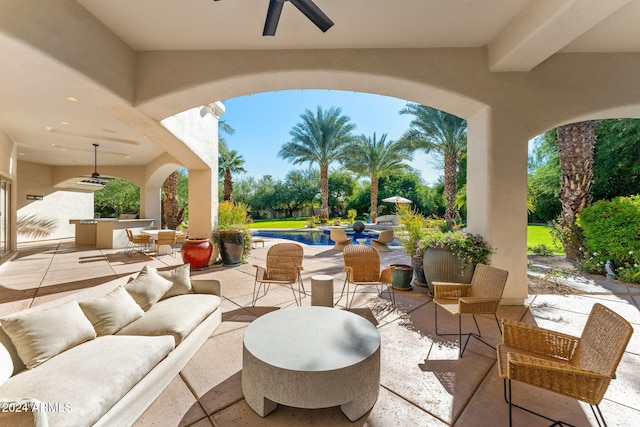 view of patio / terrace with a bar, ceiling fan, and an outdoor hangout area