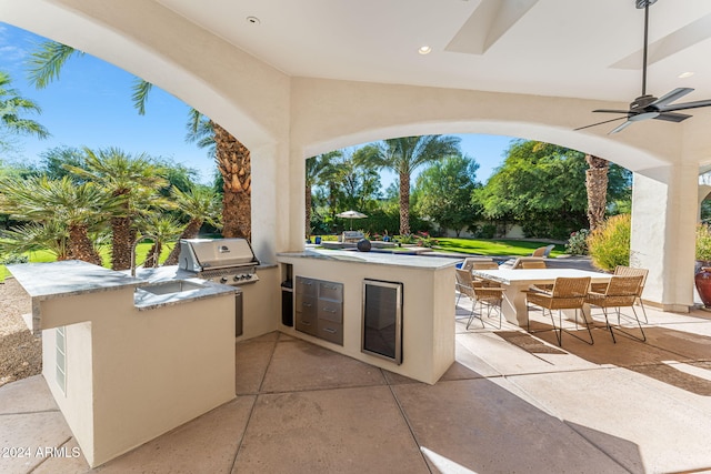 view of patio featuring area for grilling, ceiling fan, an outdoor bar, and grilling area