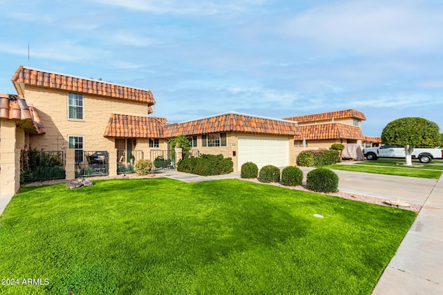 mediterranean / spanish-style house featuring a garage, fence, a tiled roof, concrete driveway, and a front yard