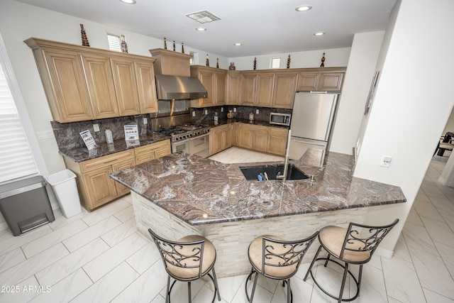 35317 N 31st Dr, Phoenix, AZ 85086 - kitchen featuring marble finish floor, a sink, dark stone countertops, stainless steel appliances, and wall chimney range hood