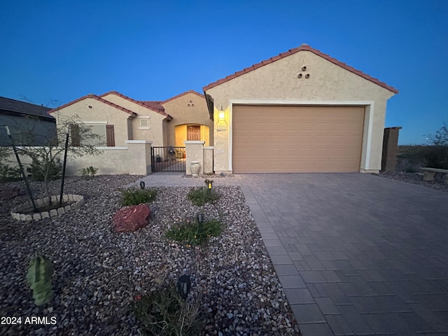 2525 N Riverside Dr, Florence, AZ 85132 - mediterranean / spanish-style house with stucco siding, decorative driveway, a tiled roof, a garage, and a gate