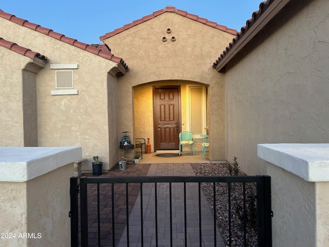 2525 N Riverside Dr, Florence, AZ 85132 - doorway to property with a gate, stucco siding, and a tiled roof