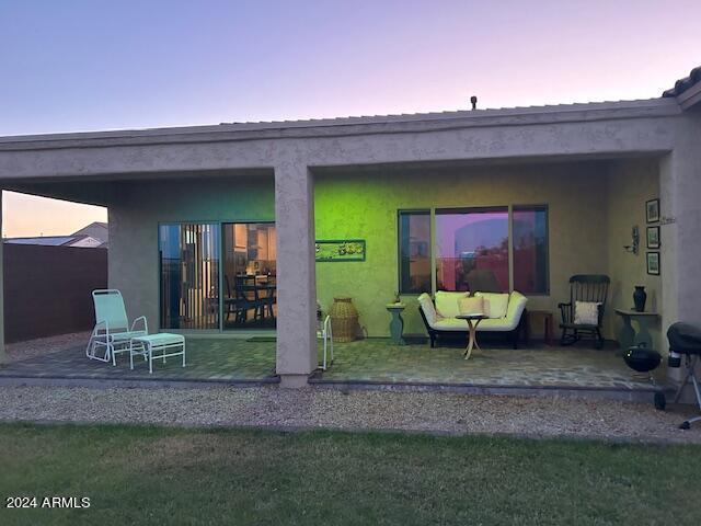 2525 N Riverside Dr, Florence, AZ 85132 - back of property at dusk with a patio and stucco siding