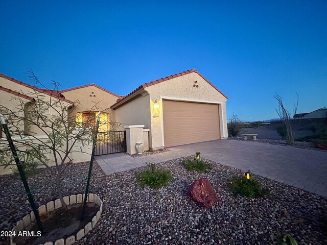 2525 N Riverside Dr, Florence, AZ 85132 - view of side of property featuring stucco siding, a tiled roof, a gate, an attached garage, and driveway