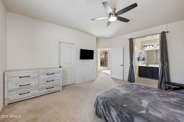bedroom featuring ensuite bathroom, light colored carpet, and ceiling fan