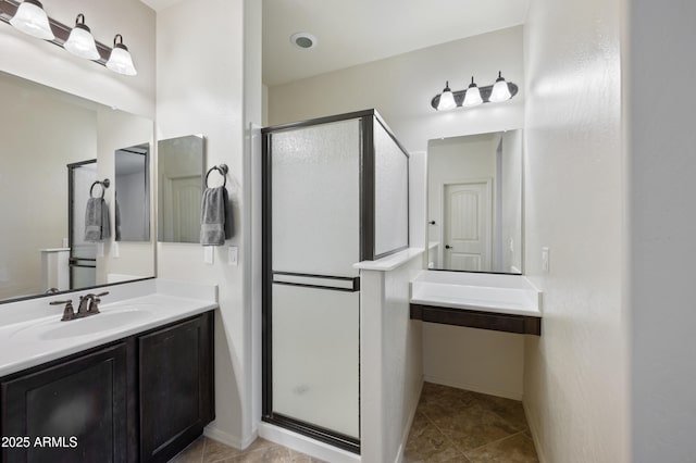 bathroom featuring tile patterned floors, baseboards, a shower stall, and vanity