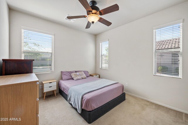 bedroom featuring light carpet, baseboards, a ceiling fan, and visible vents