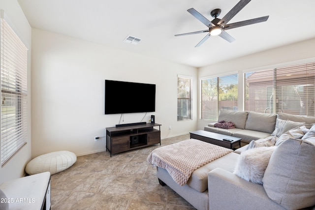 living area with visible vents, baseboards, and a ceiling fan