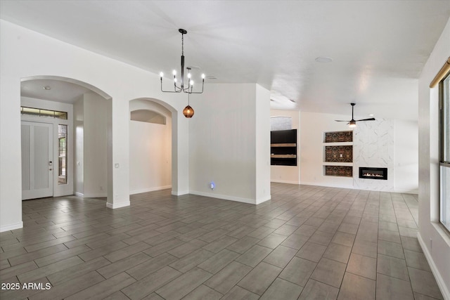 26264 N 46th St, Phoenix, AZ 85050 - unfurnished dining area featuring arched walkways, a ceiling fan, a fireplace, a chandelier, and wood tiled floors