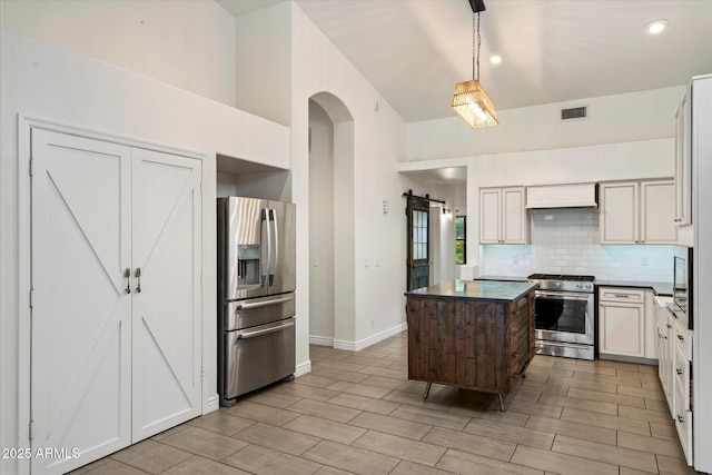 26264 N 46th St, Phoenix, AZ 85050 - kitchen featuring stainless steel appliances, dark countertops, a center island, decorative backsplash, and wood finish floors