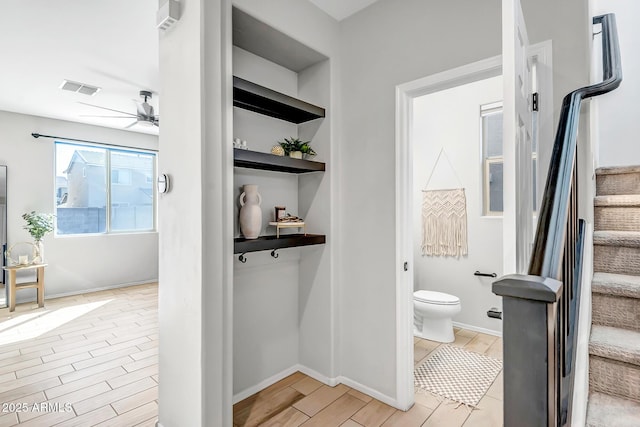 bathroom featuring ceiling fan, built in shelves, toilet, visible vents, and wood tiled floor