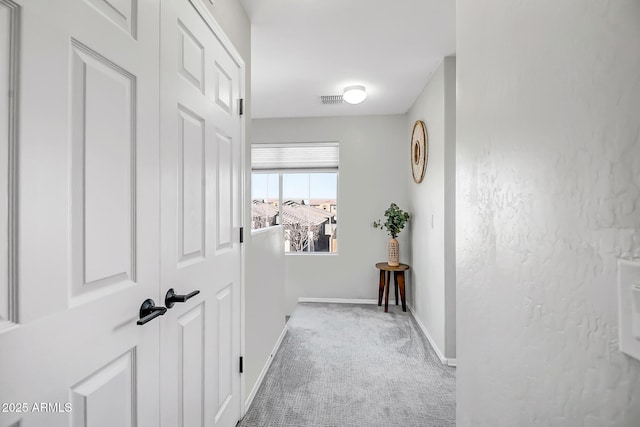 corridor featuring carpet flooring, visible vents, and baseboards