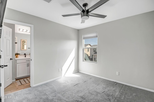 empty room featuring light carpet, a ceiling fan, and baseboards