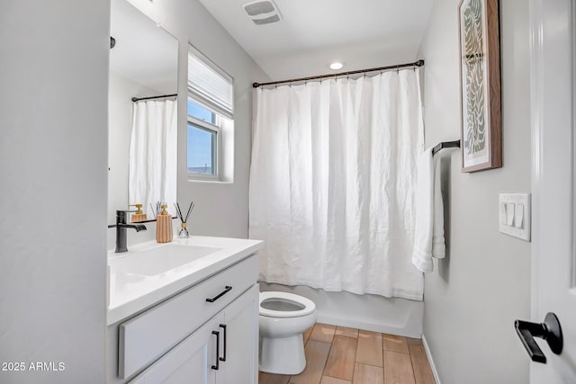 bathroom featuring wood finish floors, visible vents, shower / bathtub combination with curtain, toilet, and vanity