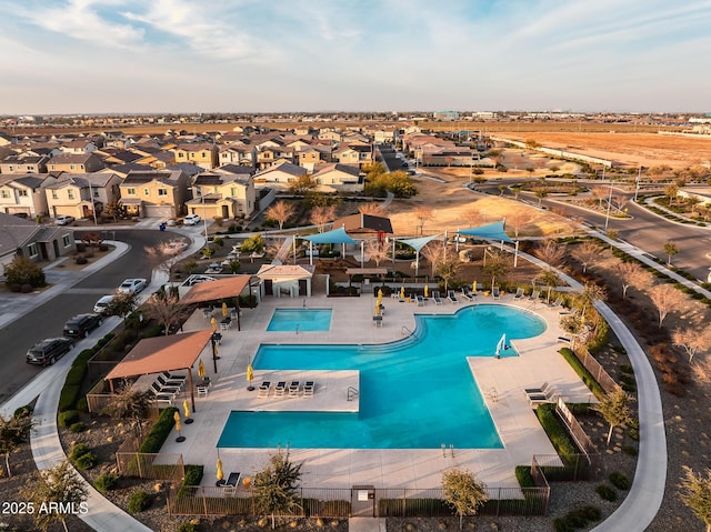 community pool with a patio area and a residential view