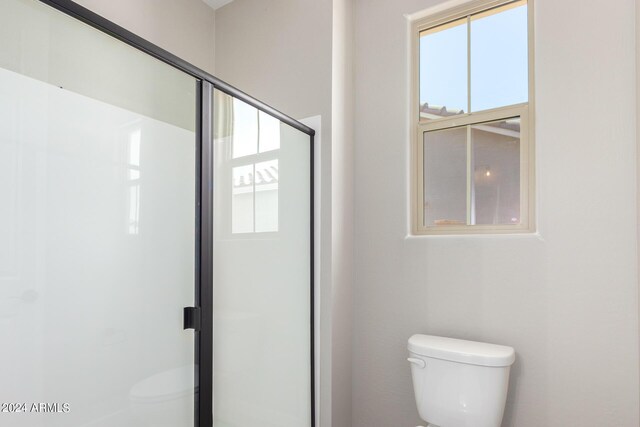 bathroom featuring walk in shower and toilet