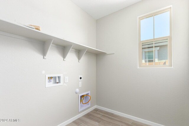 washroom with light hardwood / wood-style floors, electric dryer hookup, hookup for a washing machine, and gas dryer hookup