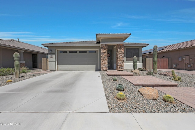 18746 W Rancho Dr, Litchfield Park, AZ 85340 - prairie-style house featuring driveway, stone siding, stucco siding, fence, and a garage