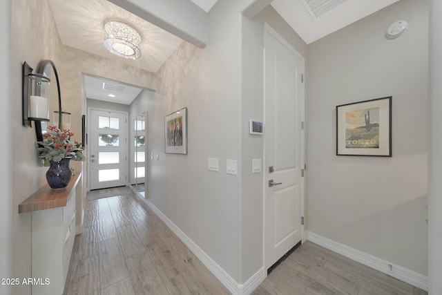 18746 W Rancho Dr, Litchfield Park, AZ 85340 - entrance foyer with baseboards, visible vents, light wood-type flooring, and an inviting chandelier