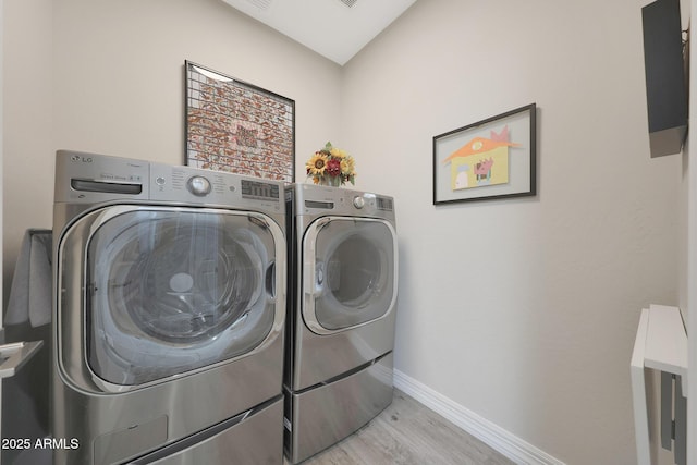 18746 W Rancho Dr, Litchfield Park, AZ 85340 - washroom with washing machine and clothes dryer, light wood-style flooring, laundry area, and baseboards