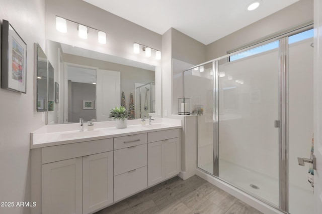 18746 W Rancho Dr, Litchfield Park, AZ 85340 - bathroom with double vanity, wood finished floors, a shower stall, and a sink