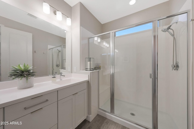 18746 W Rancho Dr, Litchfield Park, AZ 85340 - bathroom featuring wood finished floors, visible vents, vanity, and a stall shower